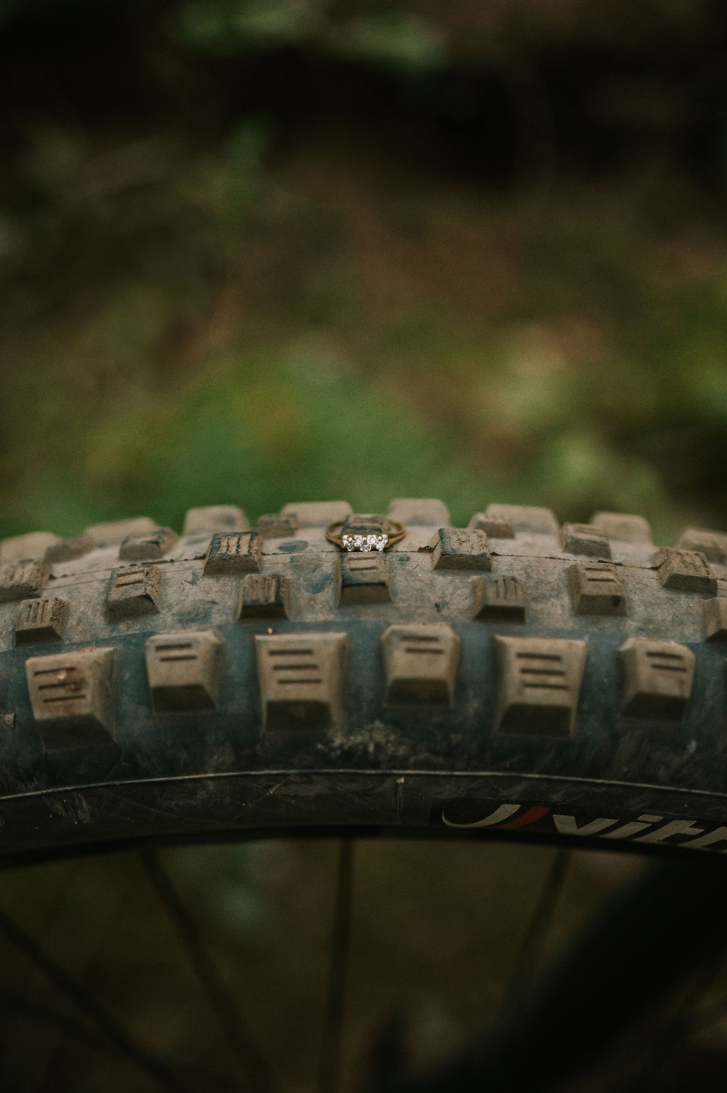 Adventurous couple photographer mountain biking through Cumberland Forest Vancouver Island engagement ring on bike tire