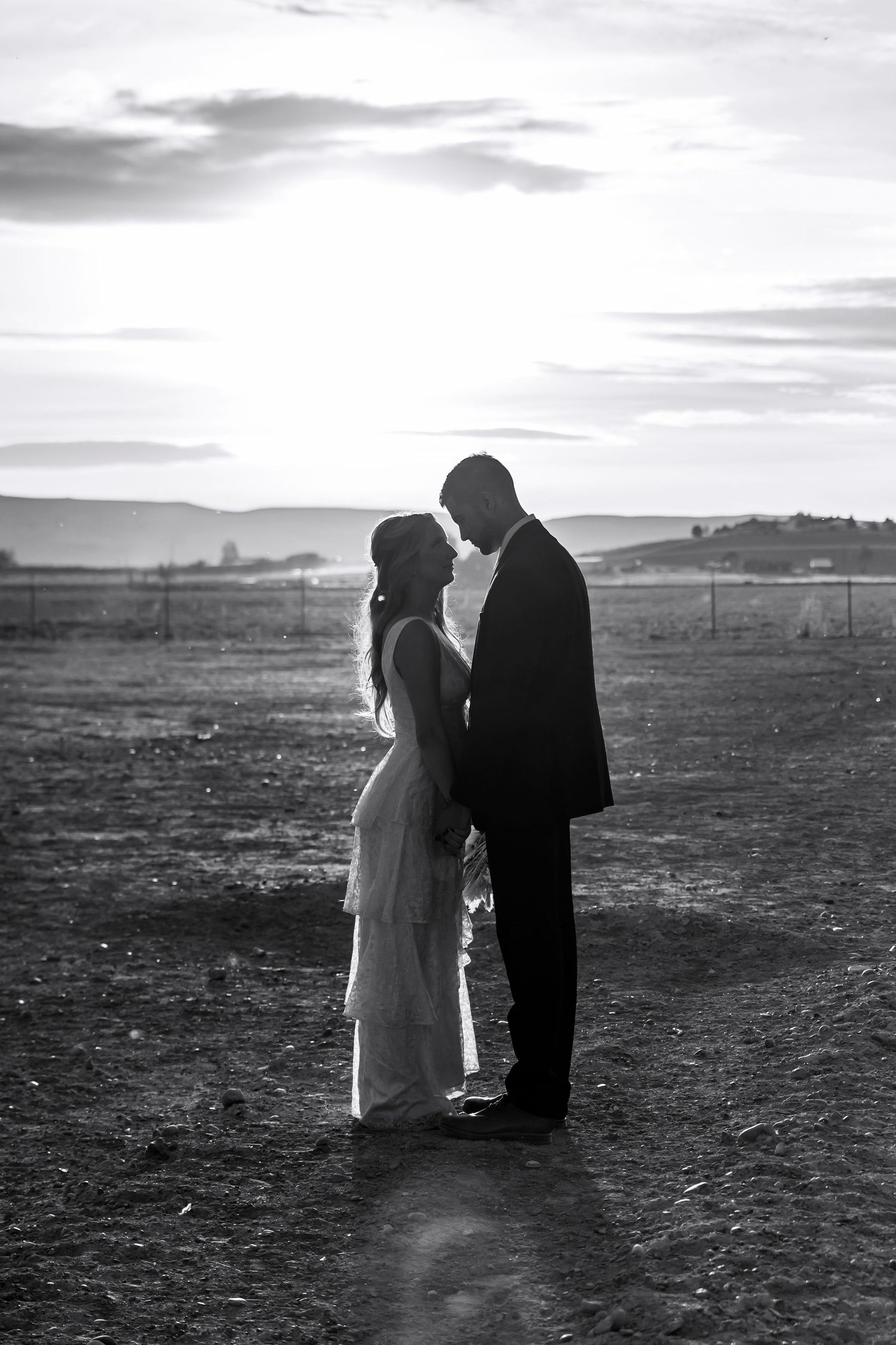 bride and groom photo on farm with mountains and the sunset