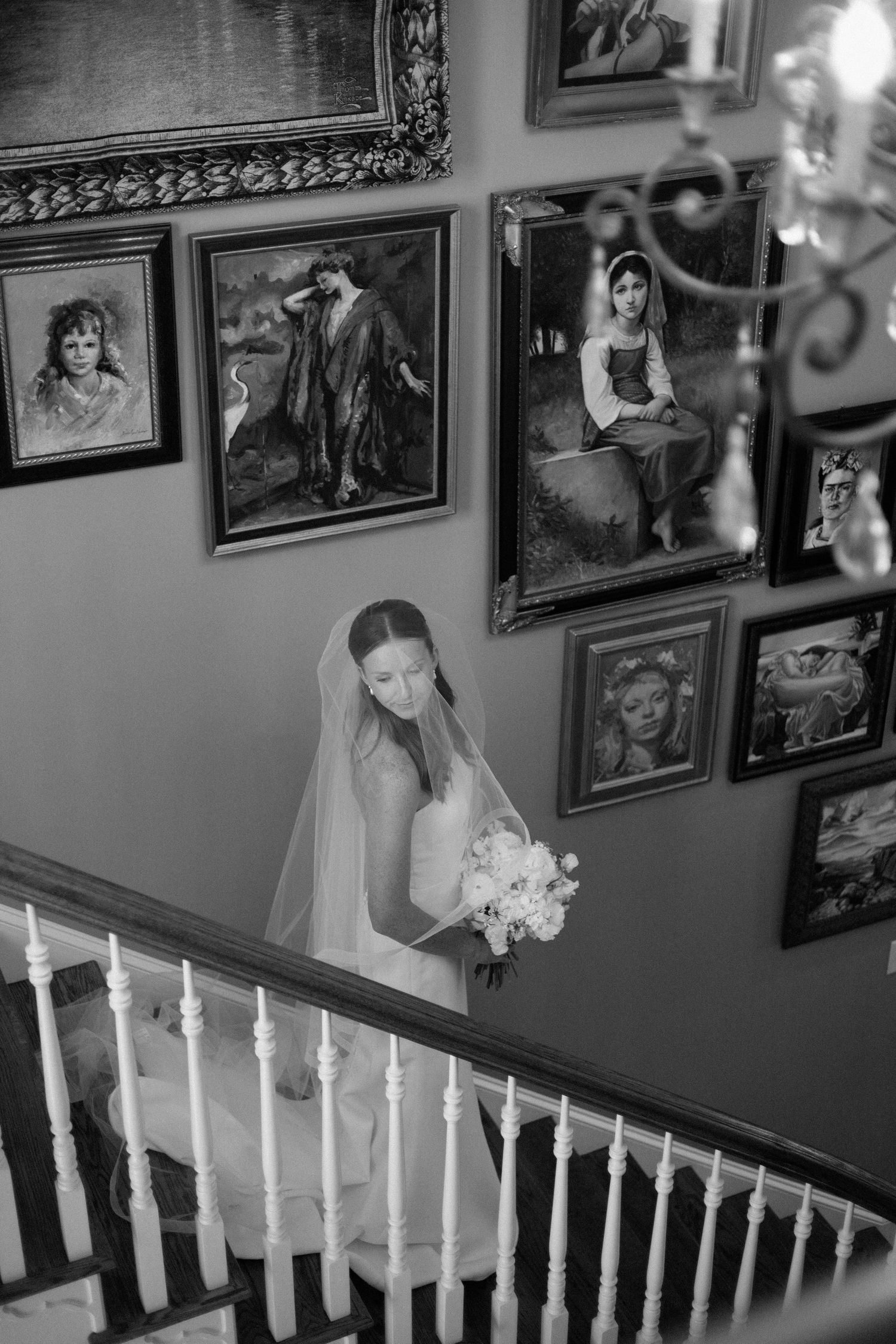 A black and white wedding photography collage showing candid moments on a staircase with framed photos on the wall.
