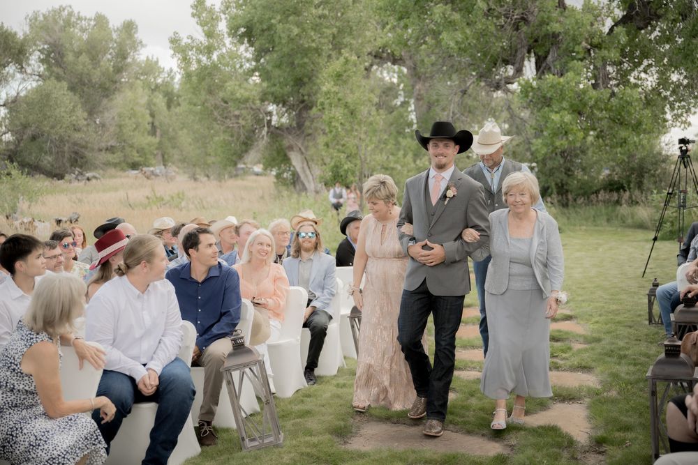 Wedding guests celebrate and dance together in an outdoor garden reception venue during a joyful summer celebration.