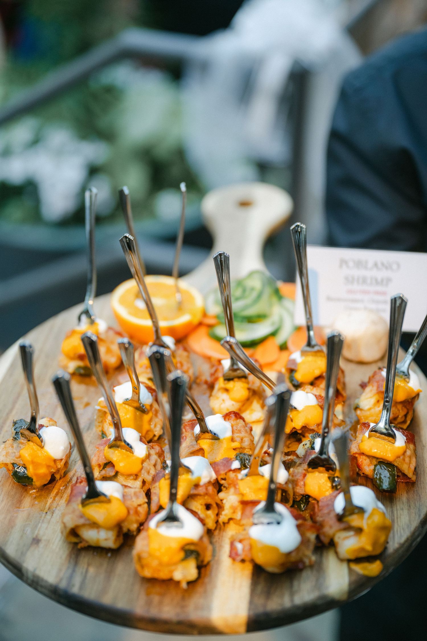 Elegant white wedding decor with delicate lanterns, floral arrangements and gold calligraphy signage at an outdoor venue.