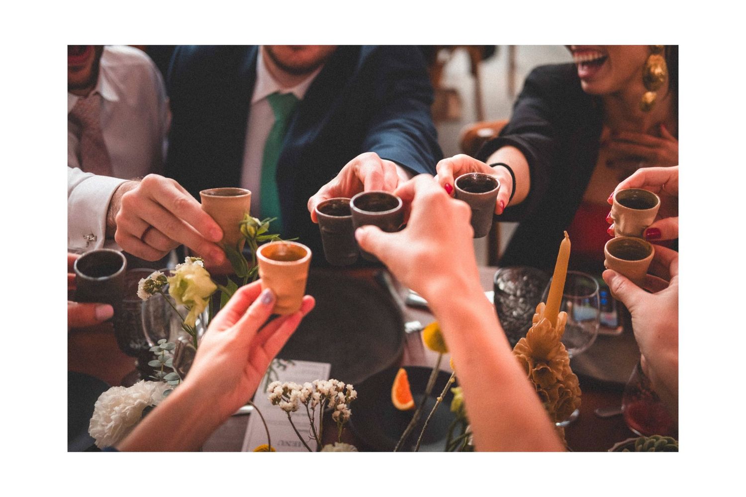 Wedding guests raise drinks and toast during reception celebration.
