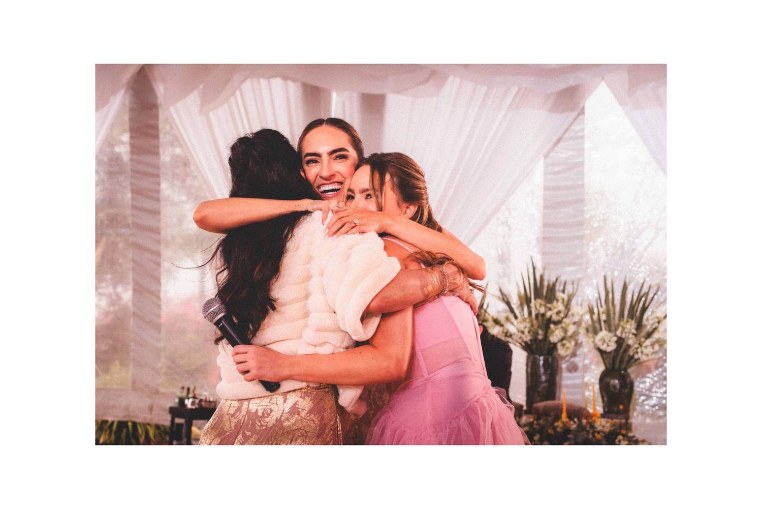 Joyful celebration moment at wedding reception with white draped decor.