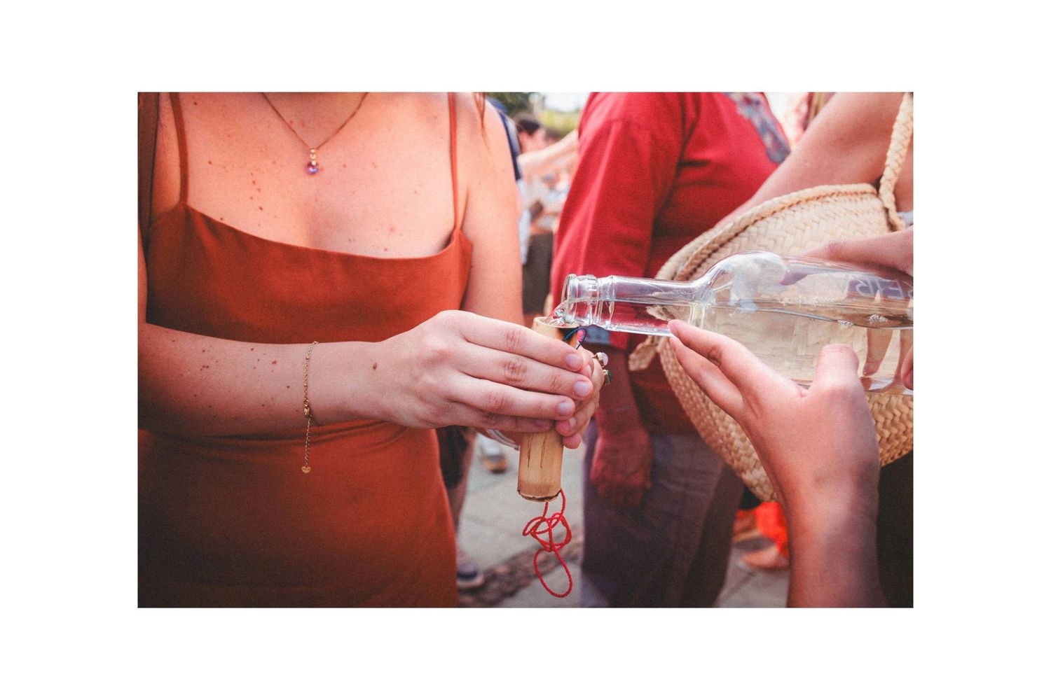 Group of tourists enjoying traditional drinks and snacks at an outdoor Mexican gathering.