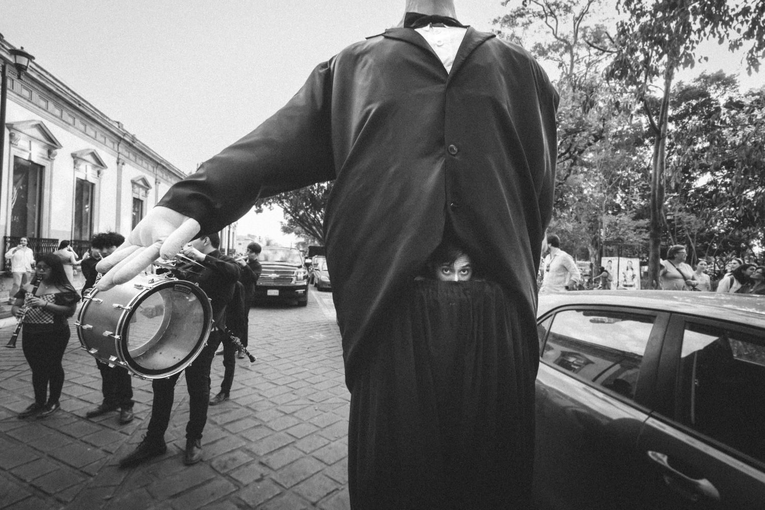 Black and white photo of musicians playing instruments during a street performance.