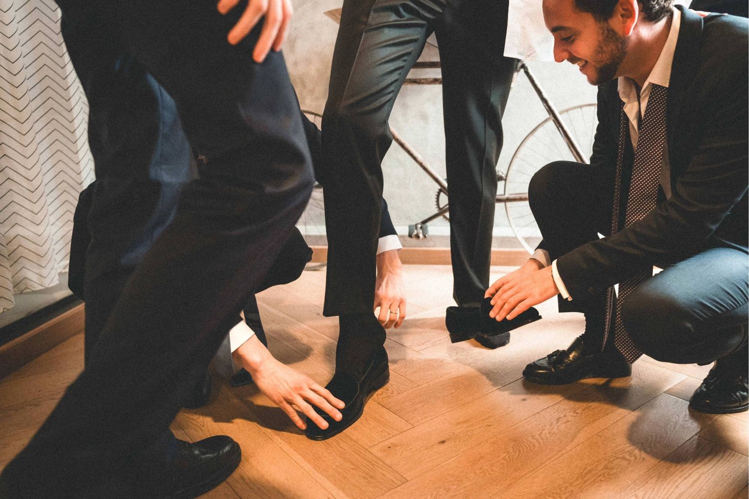 Professional group kneeling and interacting on hardwood floor in formal attire.