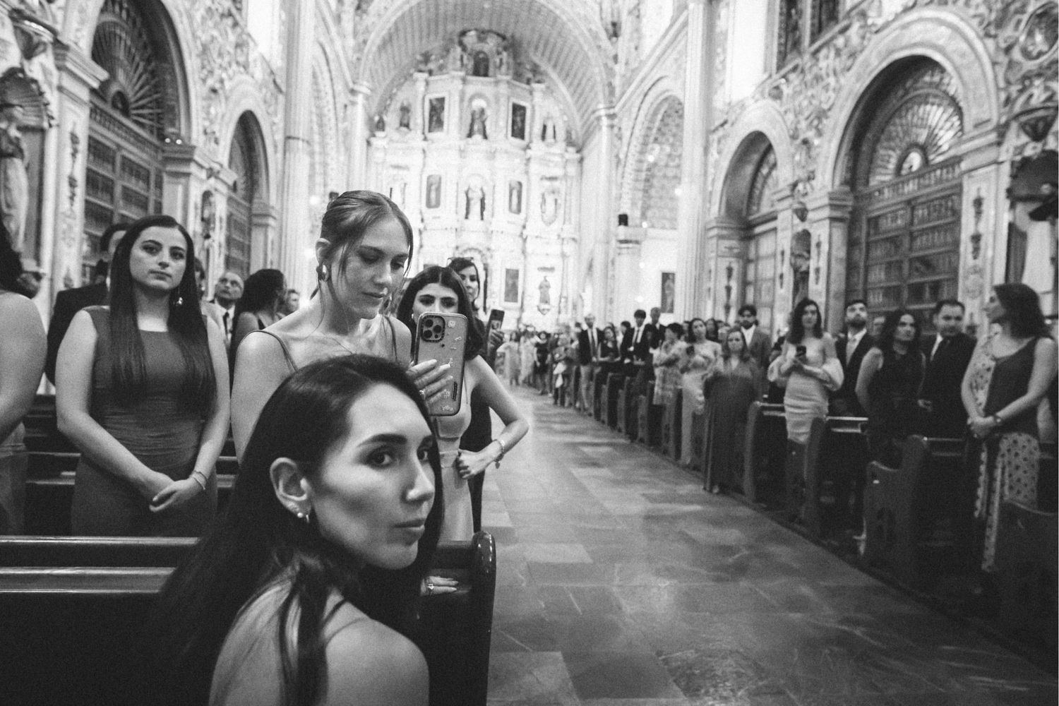 Black and white wedding photos displayed in a filmstrip style sequence showing romantic moments in a church setting.
