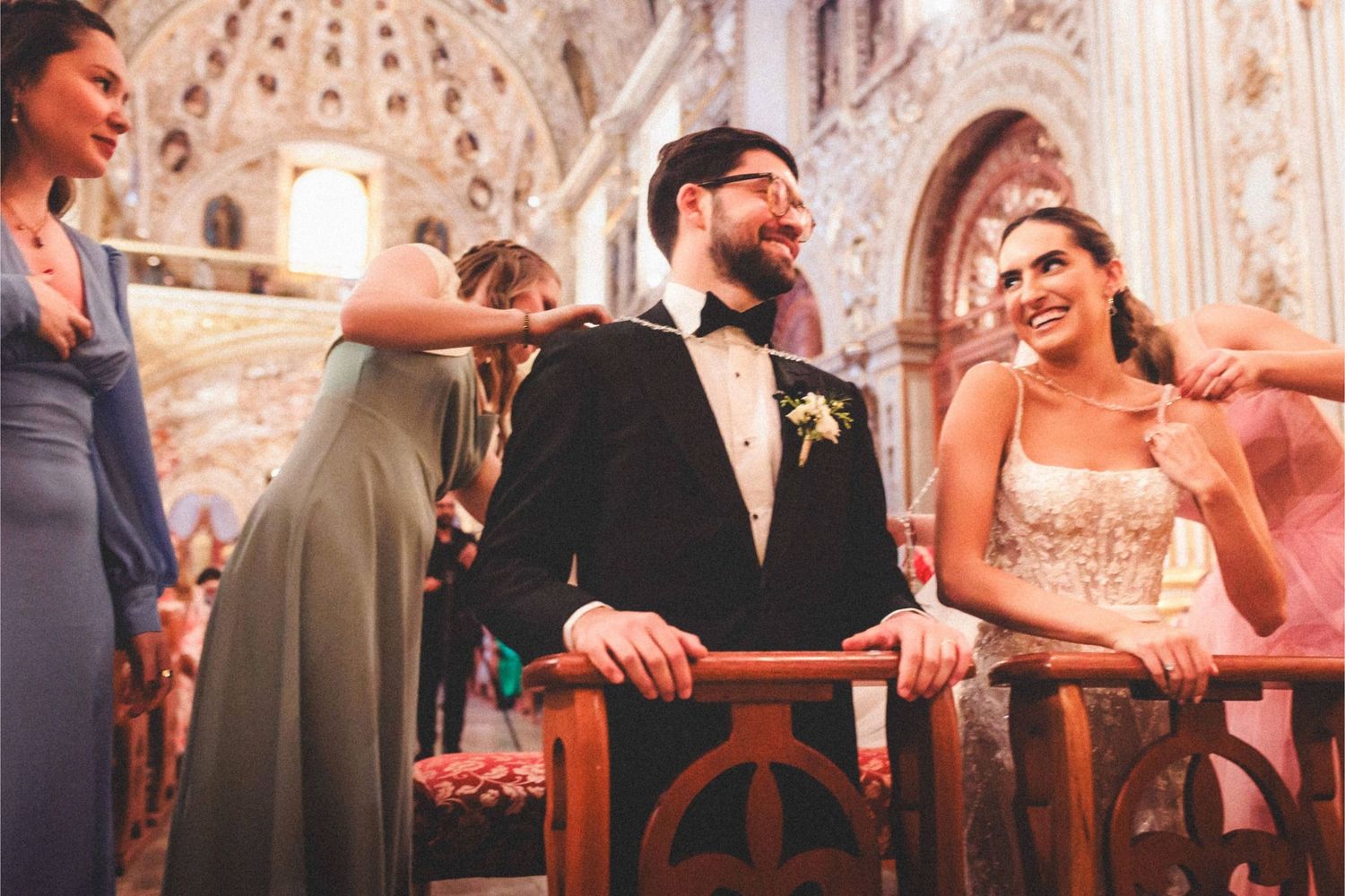 A joyful couple shares a moment together inside an ornate cathedral with vaulted ceilings and decorative architecture.