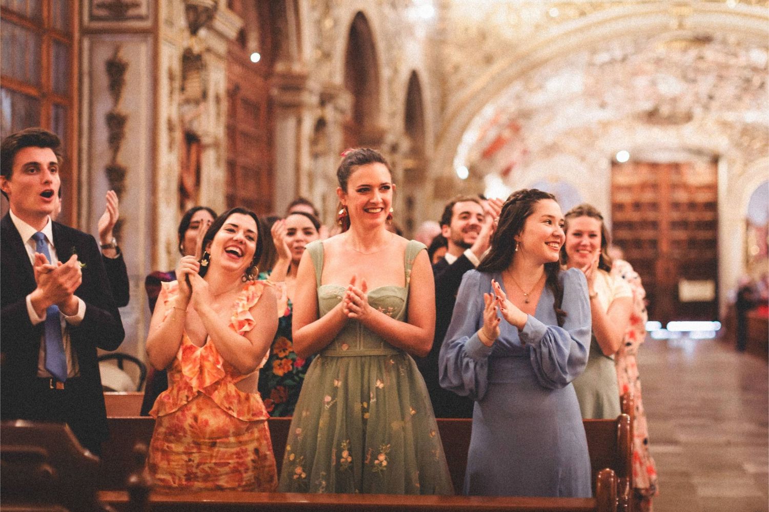 Wedding party celebrates with laughter and dancing in a historic stone venue.