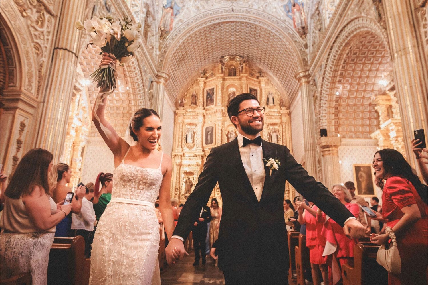 Joyful wedding ceremony taking place in a historic church with vaulted ceilings and ornate decorations.