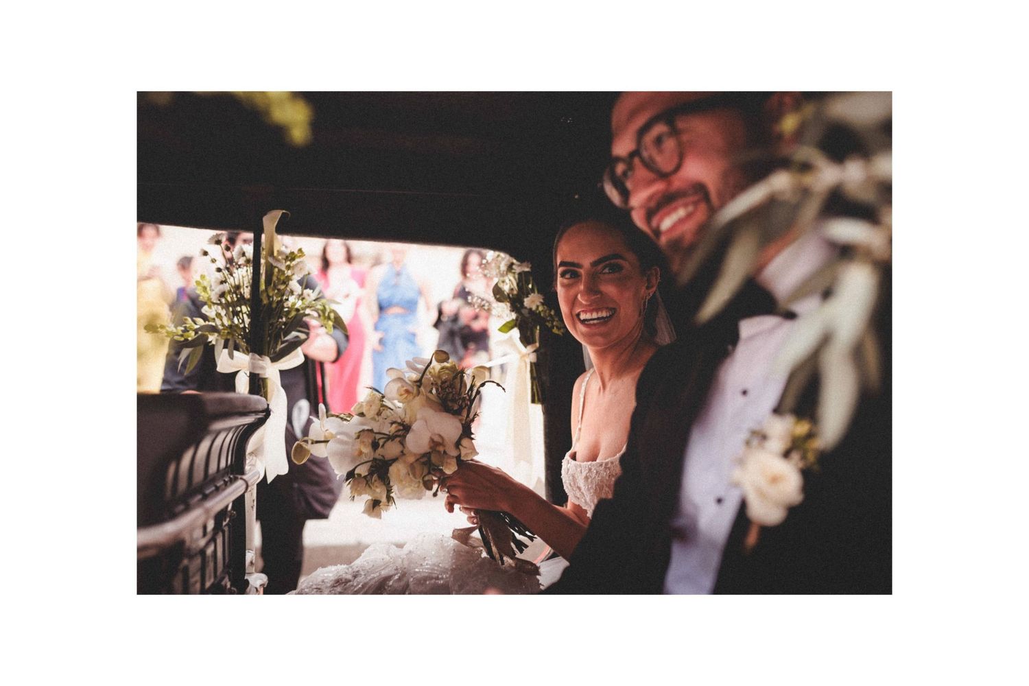 Wedding guests share joyful moments during reception celebrations in a dimly lit venue.