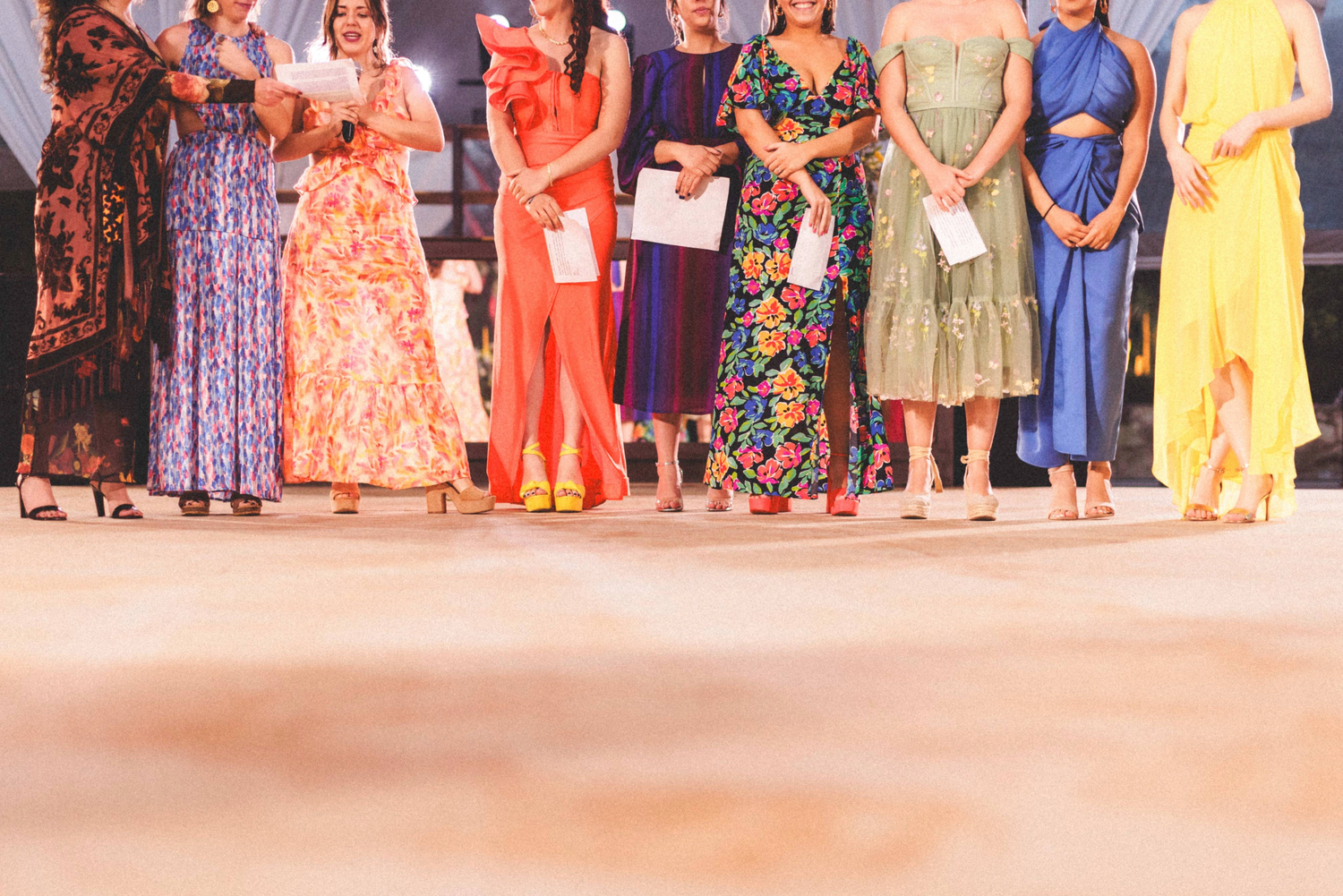 A group of people wearing colorful traditional clothing stand in a line during a cultural celebration or event.