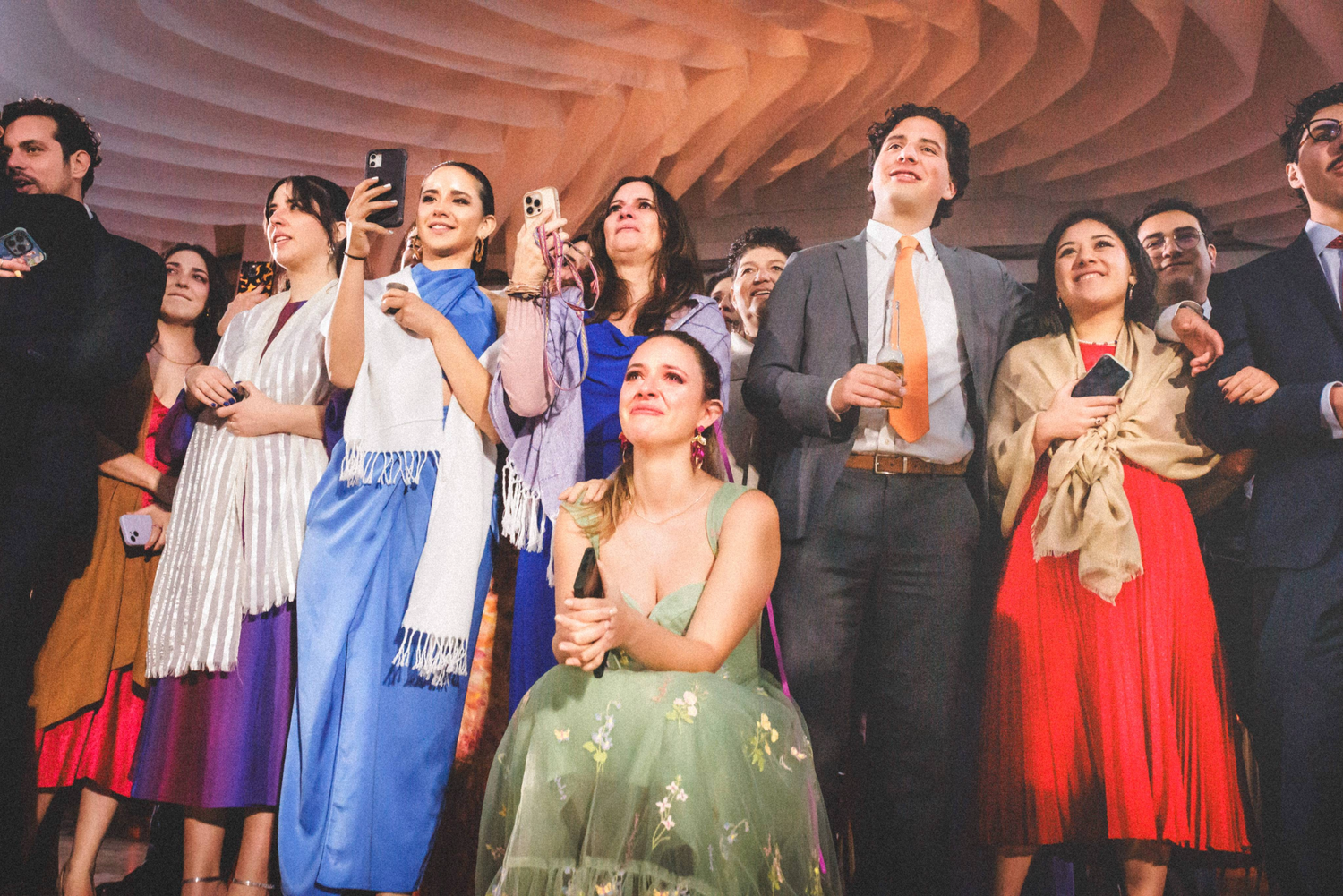 Performers on stage take a bow during the finale of a theatrical production with dramatic lighting and colorful costumes.