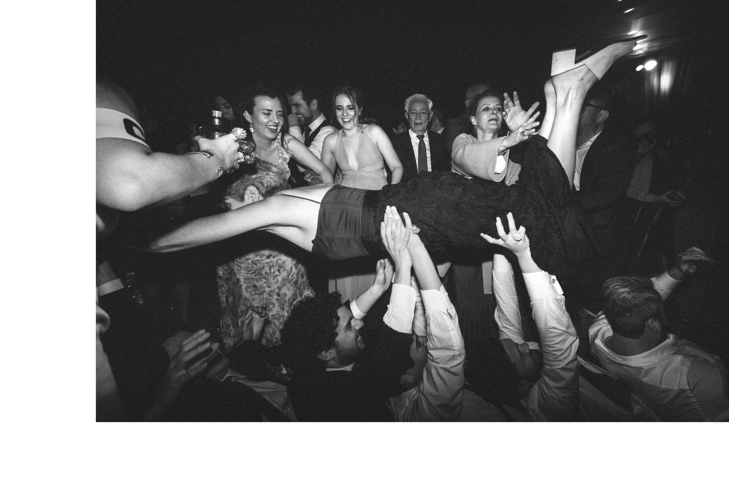 A group of people dancing and enjoying themselves at a lively party or nightclub in black and white.