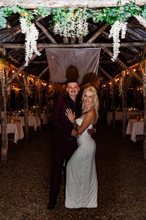 A wedding reception venue decorated with hanging white flowers and lights creating a romantic ambiance.