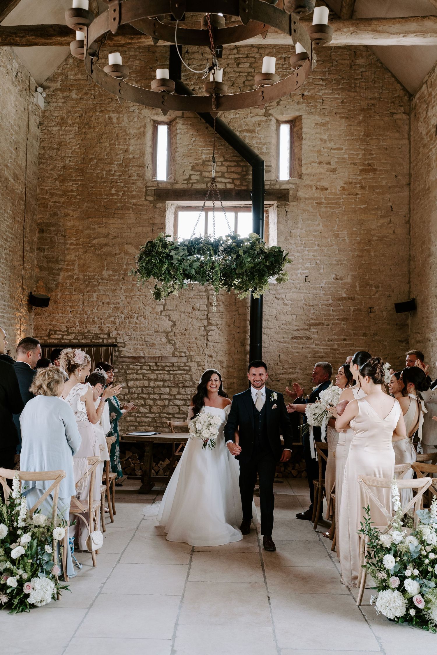 bride and groom walking down aisle as husband and wife, exiting wedding ceremony at yardspace old gore in cirencester