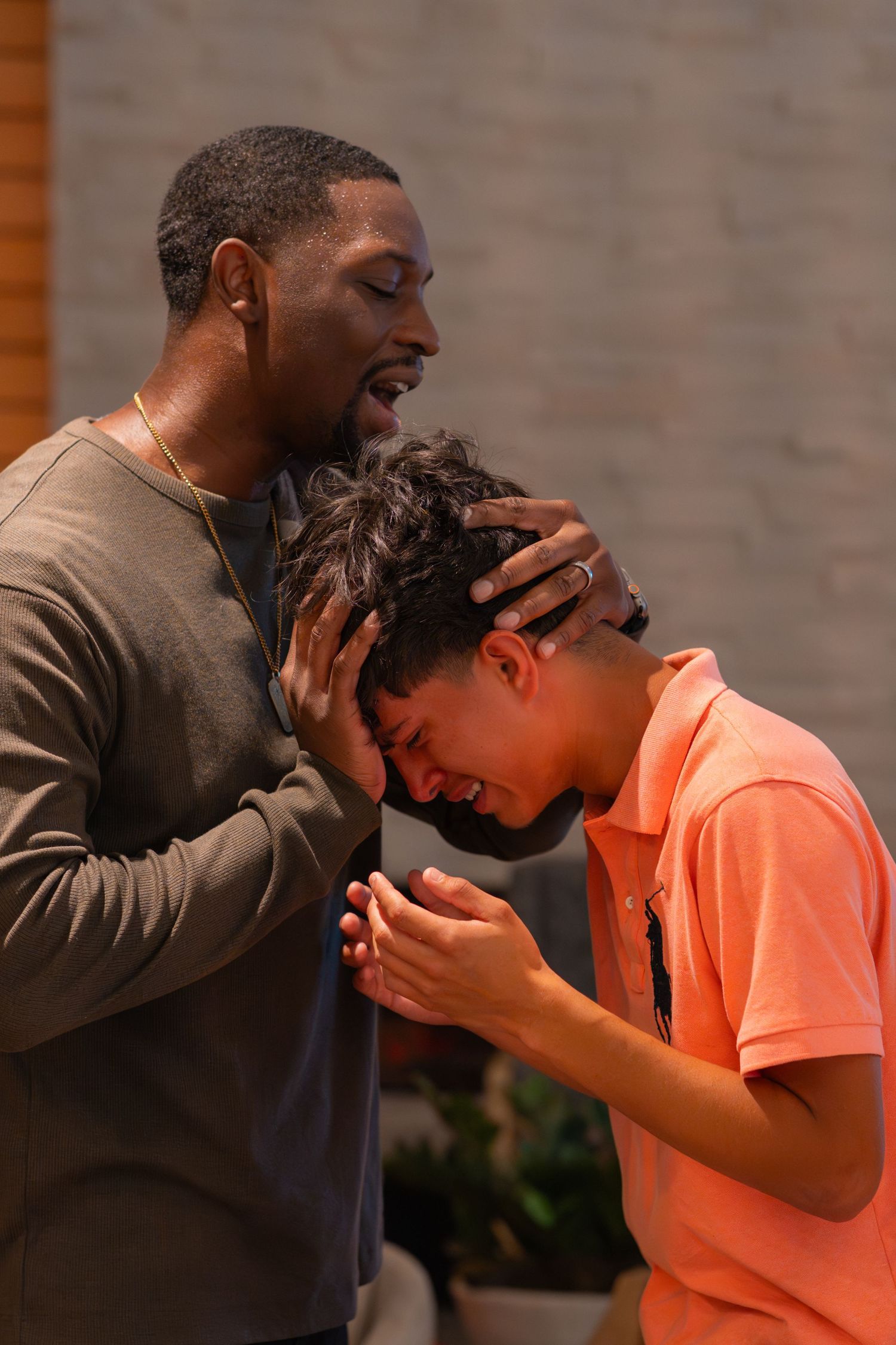 A person wearing glasses and a light-colored shirt in contemplative prayer.