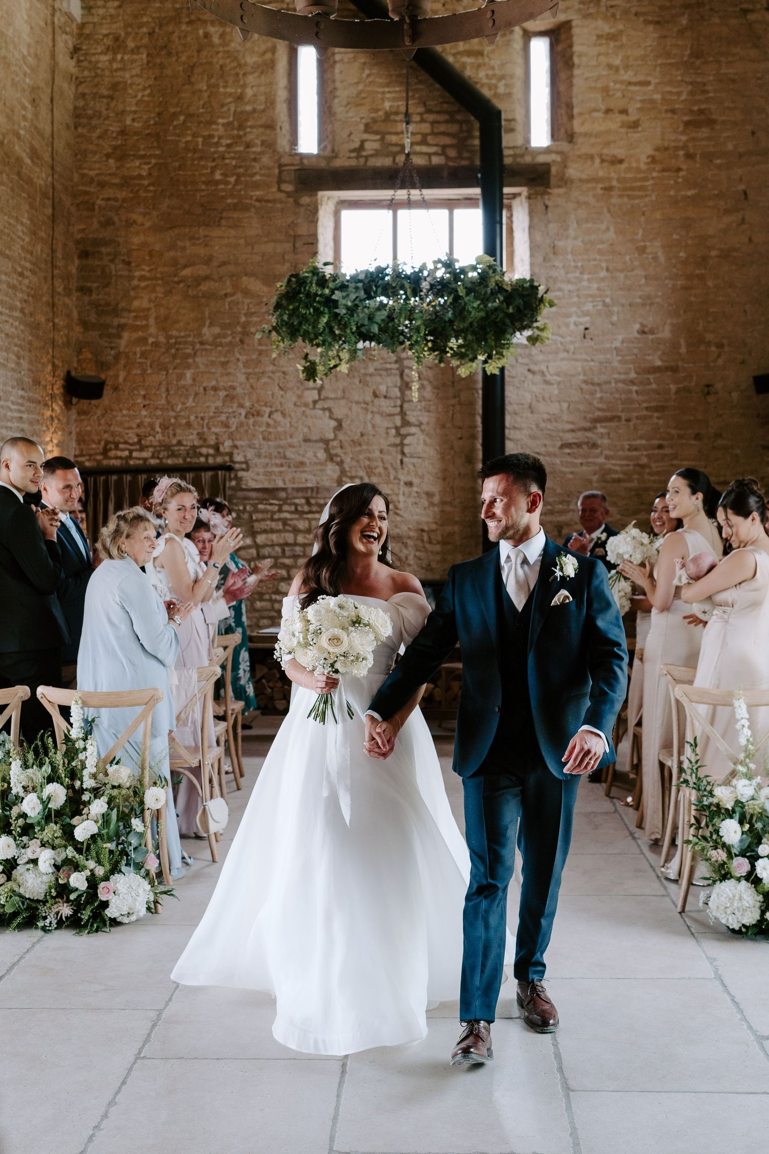 bride and groom walking down aisle as husband and wife, exiting wedding ceremony at yardspace old gore in cirencester