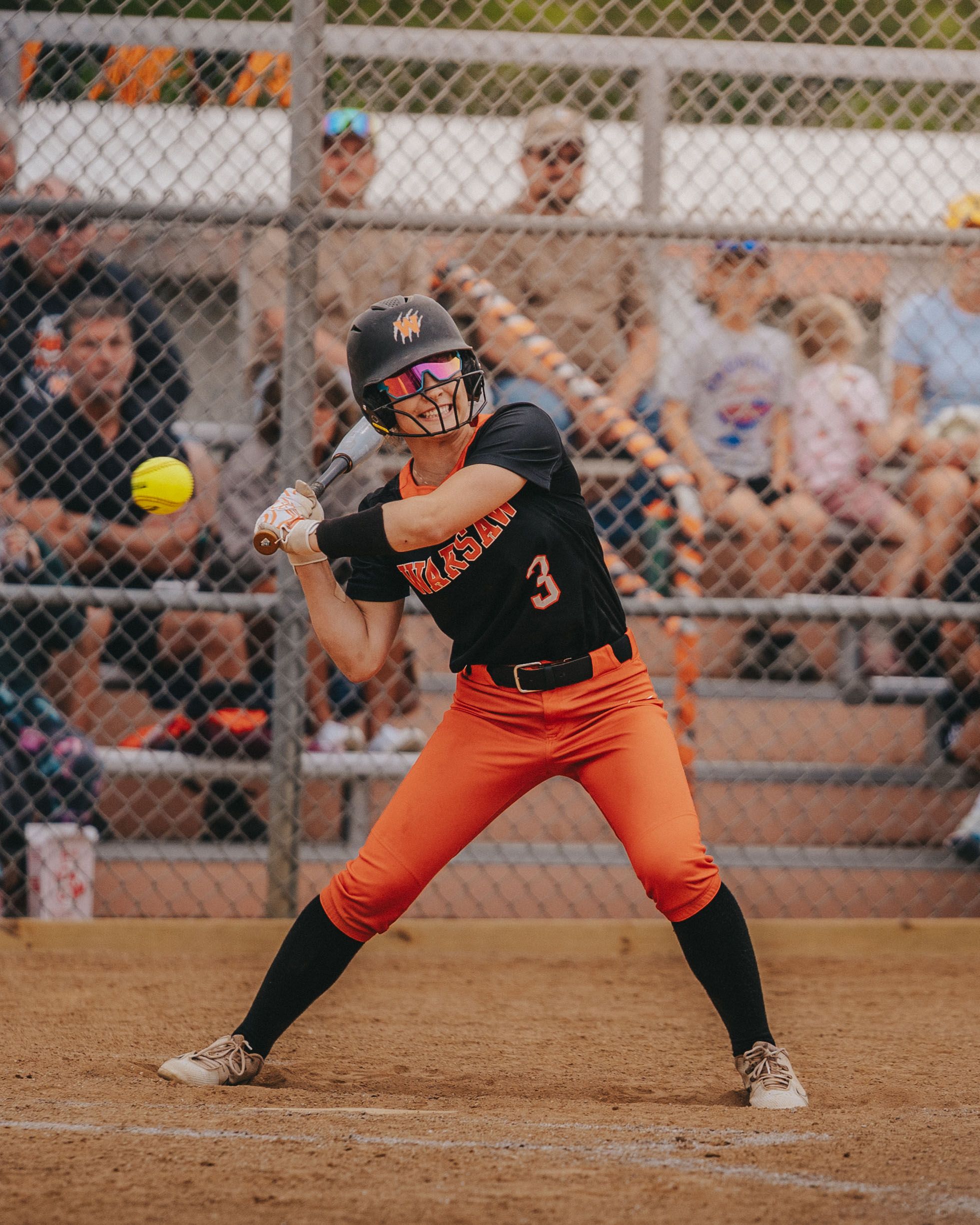 Sports Photography of a softball batter in orange and black uniform preparing to hit during game - Warsaw, Indiana