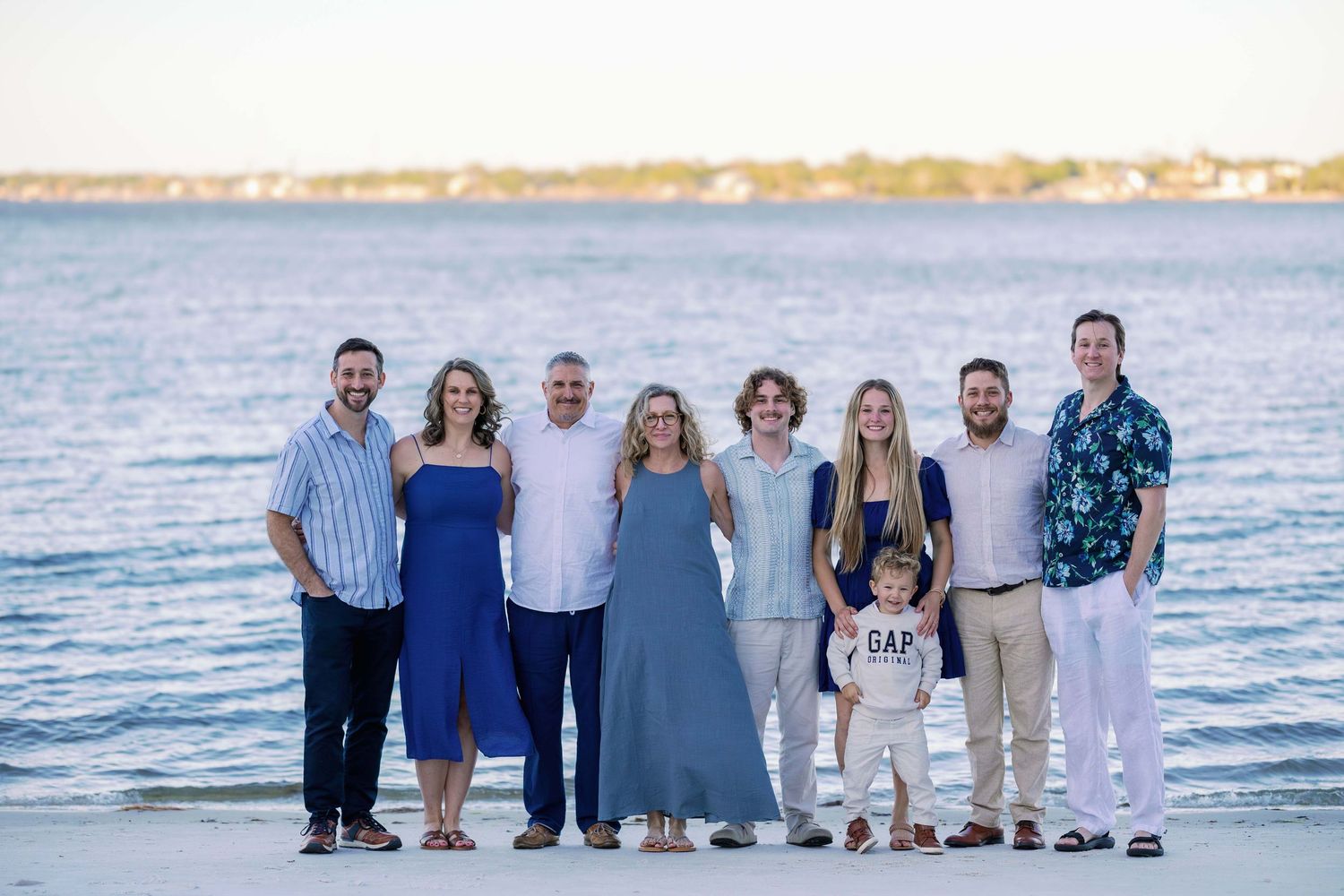 A group in coordinated blue and white outfits poses together under a large oak tree with hanging moss.