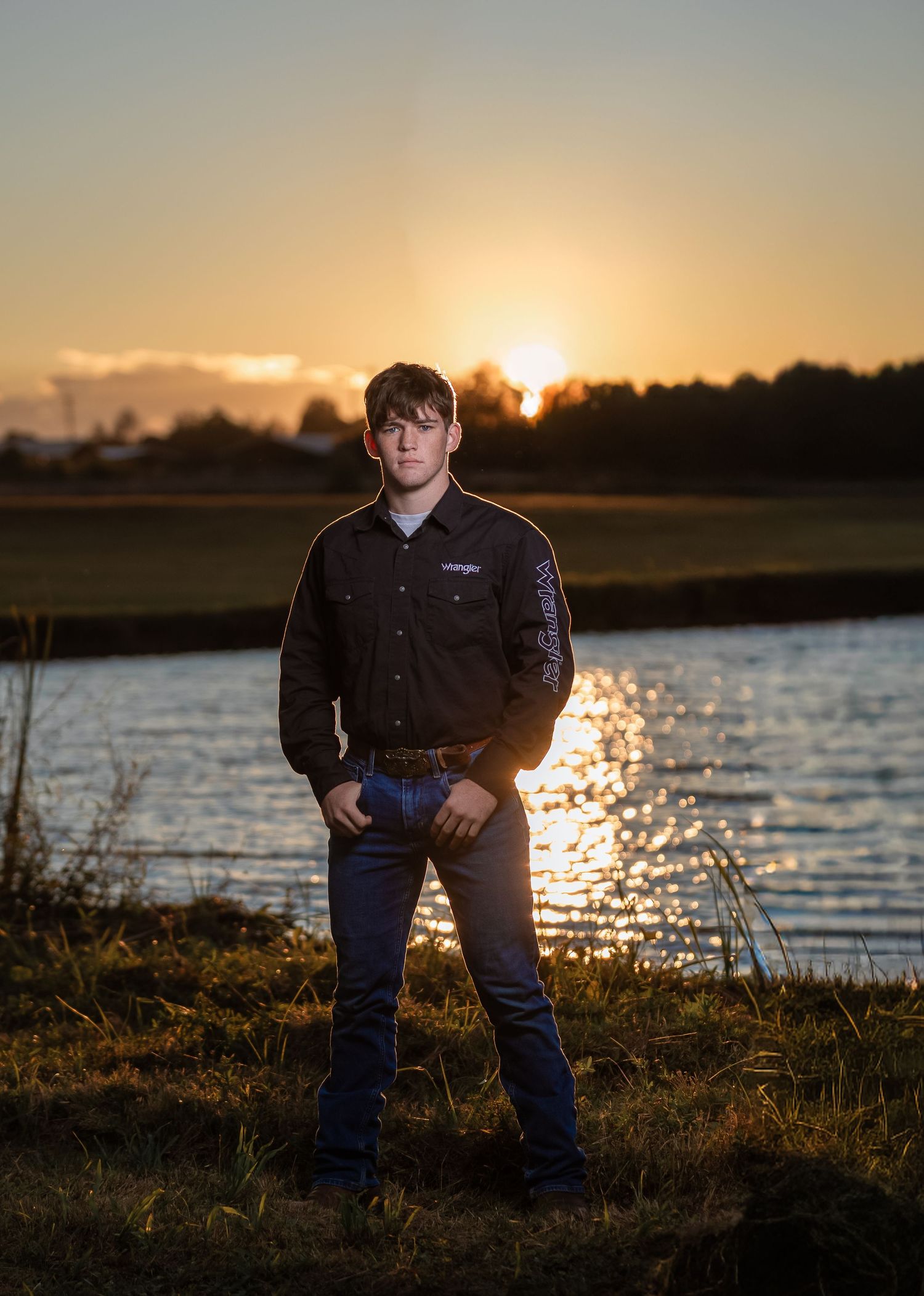 Outdoor male senior portrait by a lake at sunset during golden hour in Lincoln, Alabama