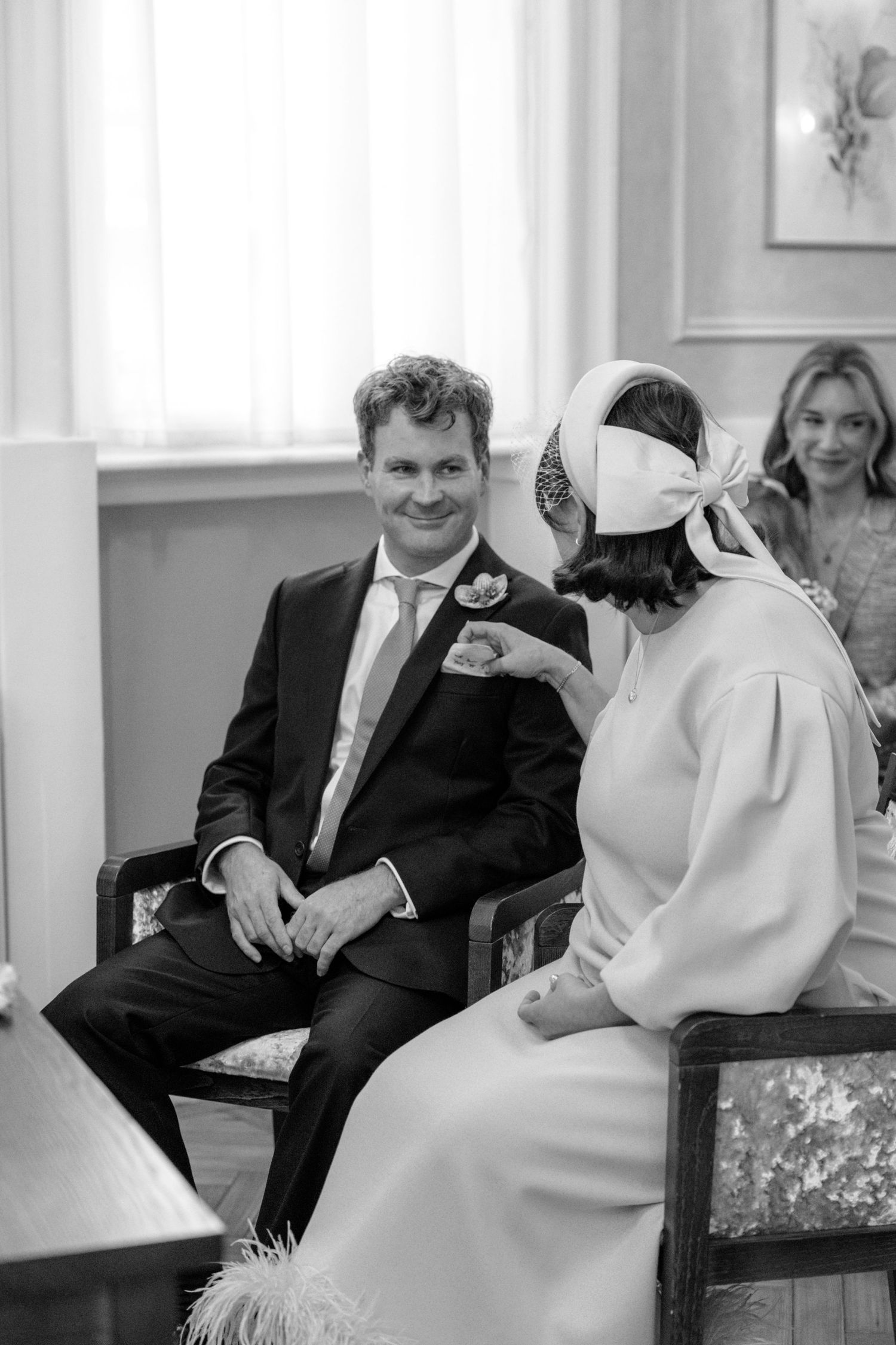 Black and white photo of wedding guests seated in formal attire.