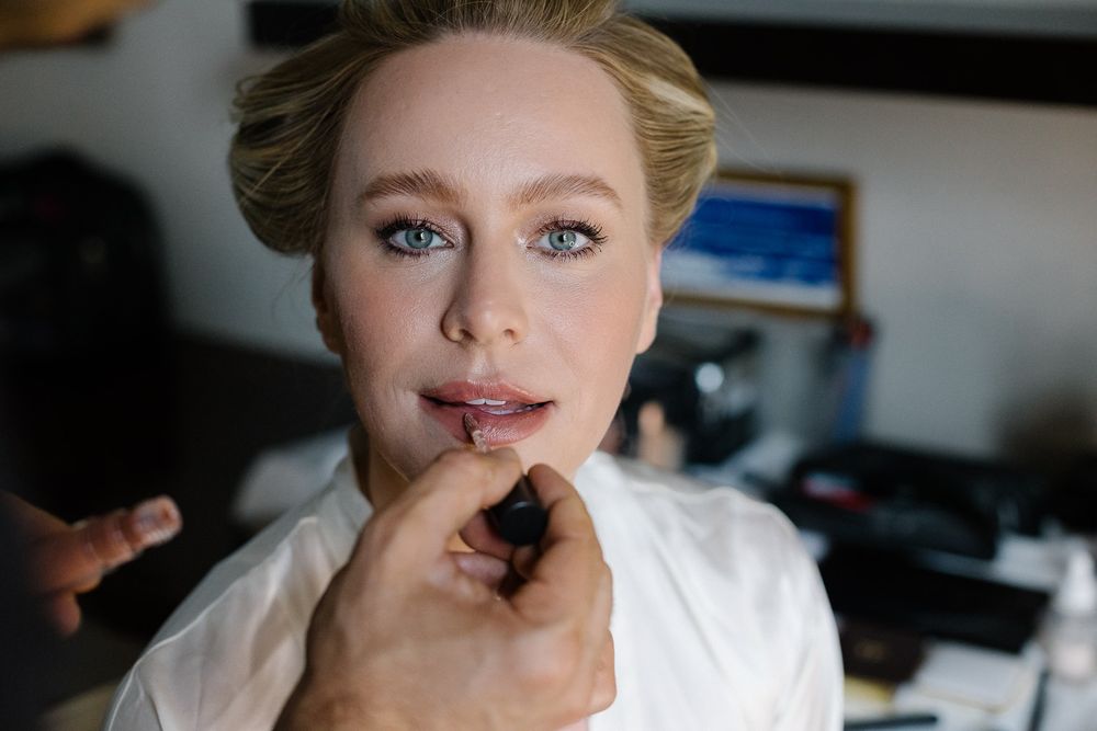 Wedding preparation scene with makeup application in progress.