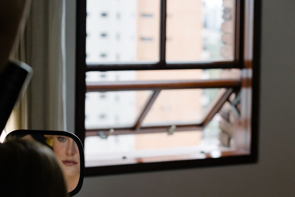 Side mirror reflection of a window frame in natural lighting.