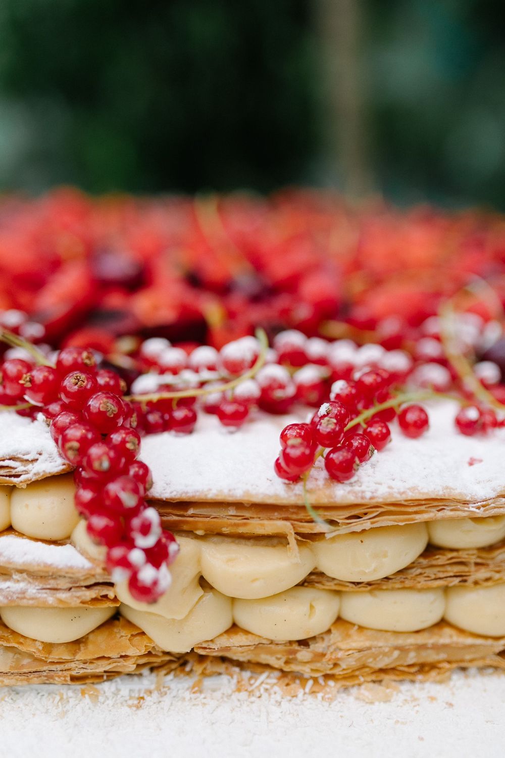 Elegant pastry with red currants and cream filling between flaky layers.
