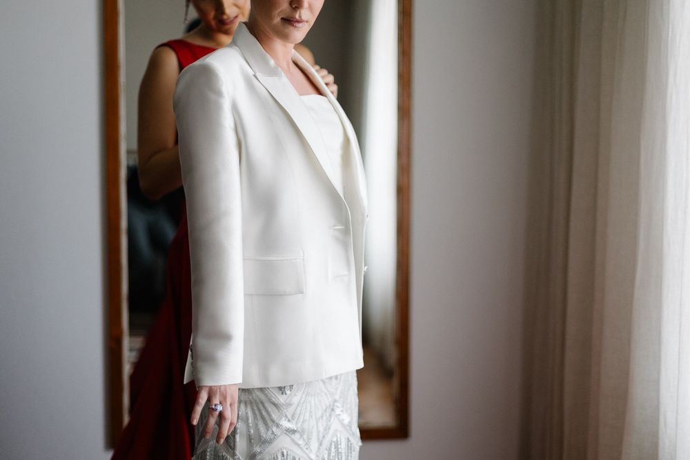 An elegant white wedding suit ensemble with lace detailing captured in soft natural light.