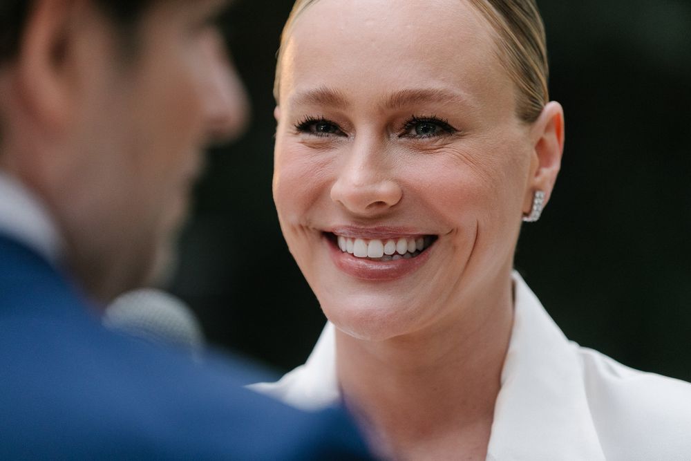 A candid moment between a couple at an outdoor wedding ceremony.