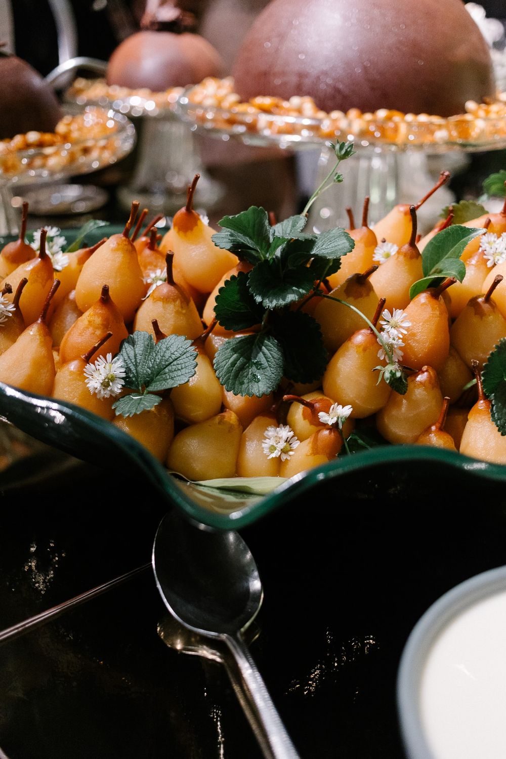Artfully plated yellow pear appetizers garnished with fresh herbs and edible flowers.