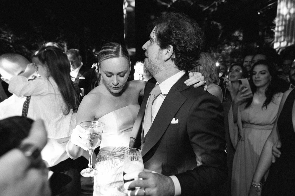 Black and white candid photo of celebratory moments at an elegant evening wedding reception.