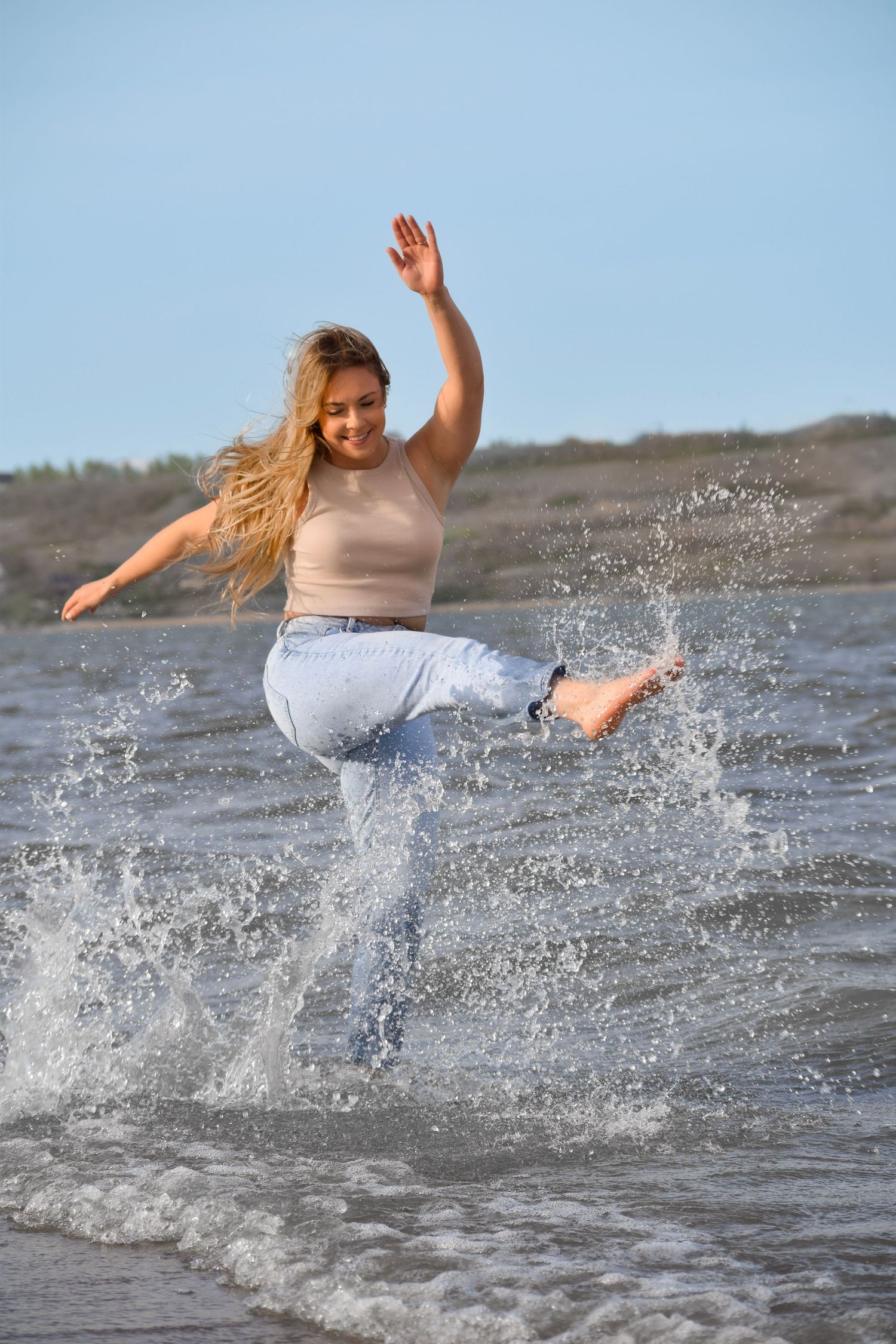 Action shot of someone splashing and kicking water at the beach.