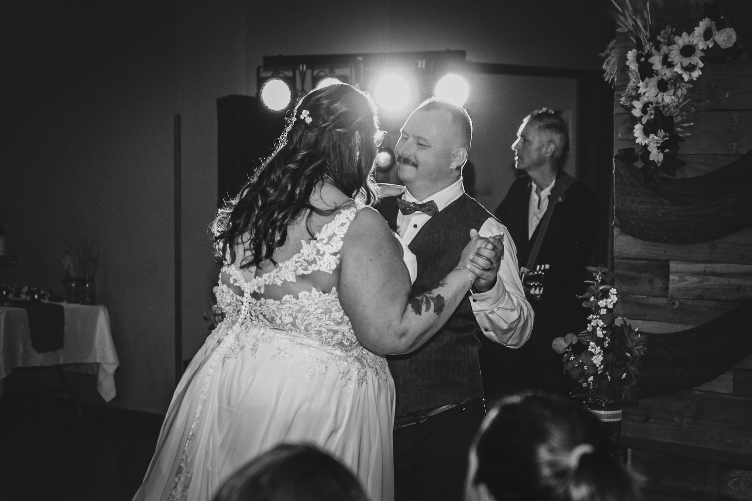 Wedding party celebrates joyfully in a dimly lit reception venue.