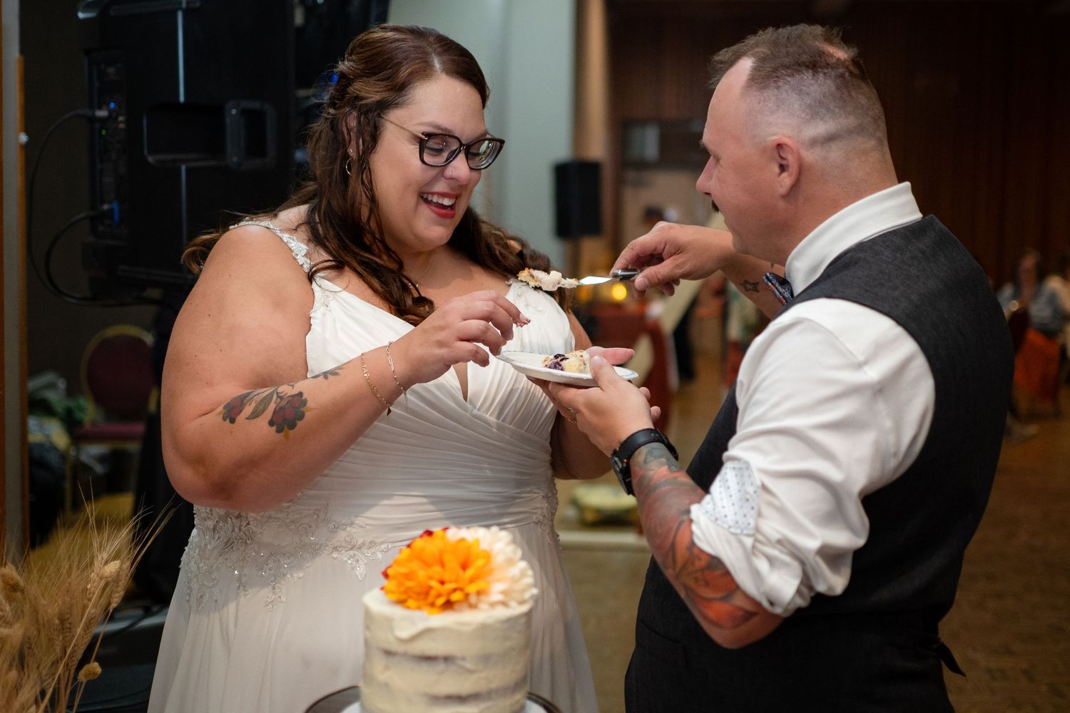 Wedding celebration with cake cutting moment at reception.