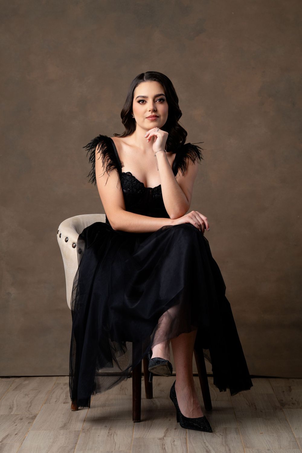Elegant black evening dress photographed in dramatic studio lighting.