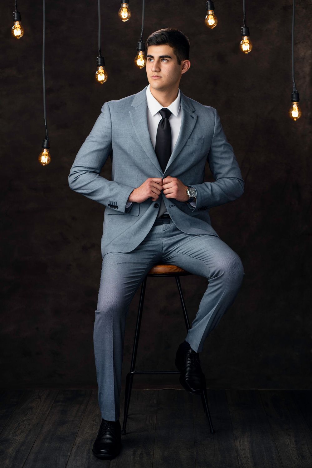 Professional grey suit photographed against dark background with vintage lighting.