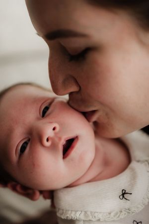 A tender series of close-up shots showing gentle kisses being given to a baby's face.