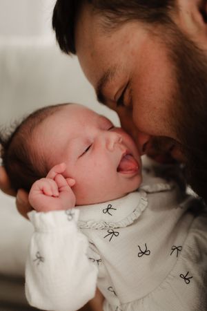 A tender moment captured in a series of black and white photos showing gentle interaction with a sleeping newborn.
