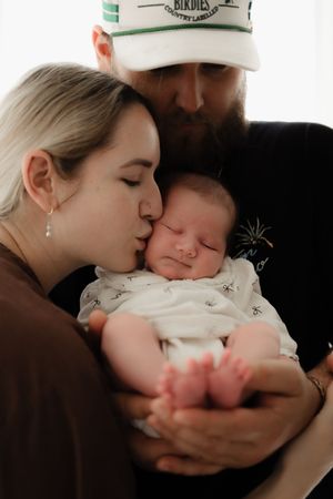A series of intimate family portraits showing loving moments with a baby in soft, natural lighting.