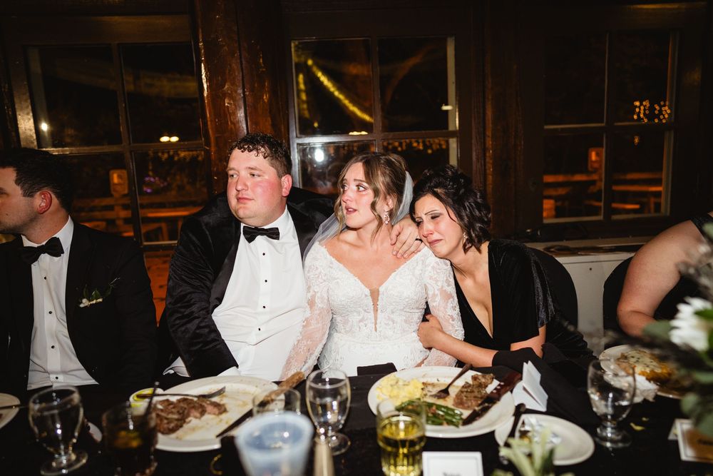 Wedding reception guests seated at elegant tables with formal place settings and decor.