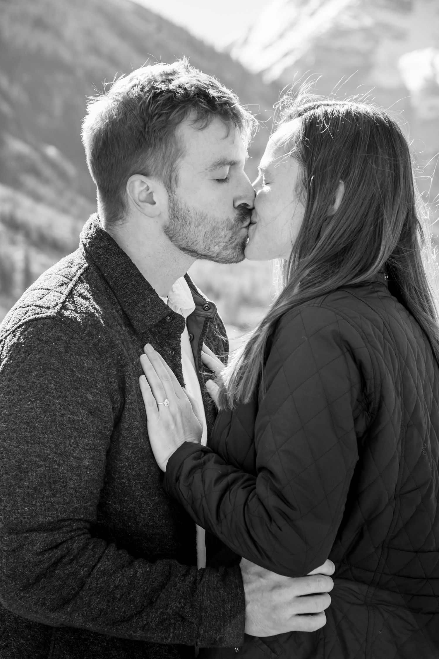 A romantic black and white photo of a couple in front of The Maroon Bells in Aspen Colorado