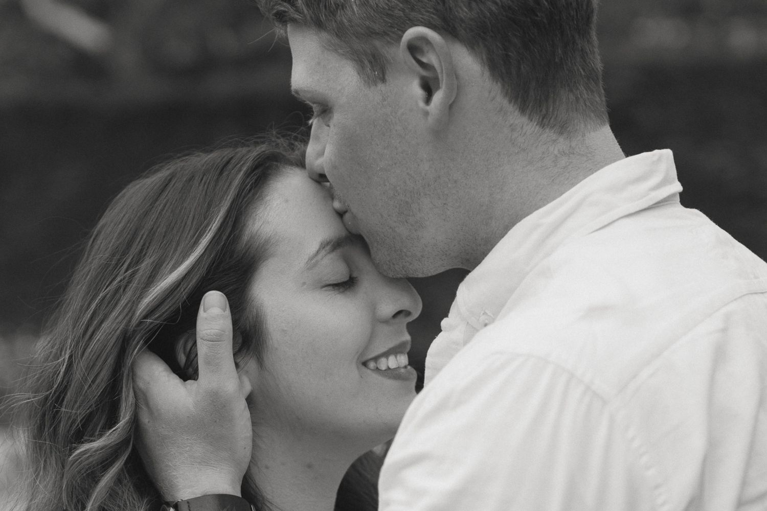 a husband kissing his wife on the forehead.