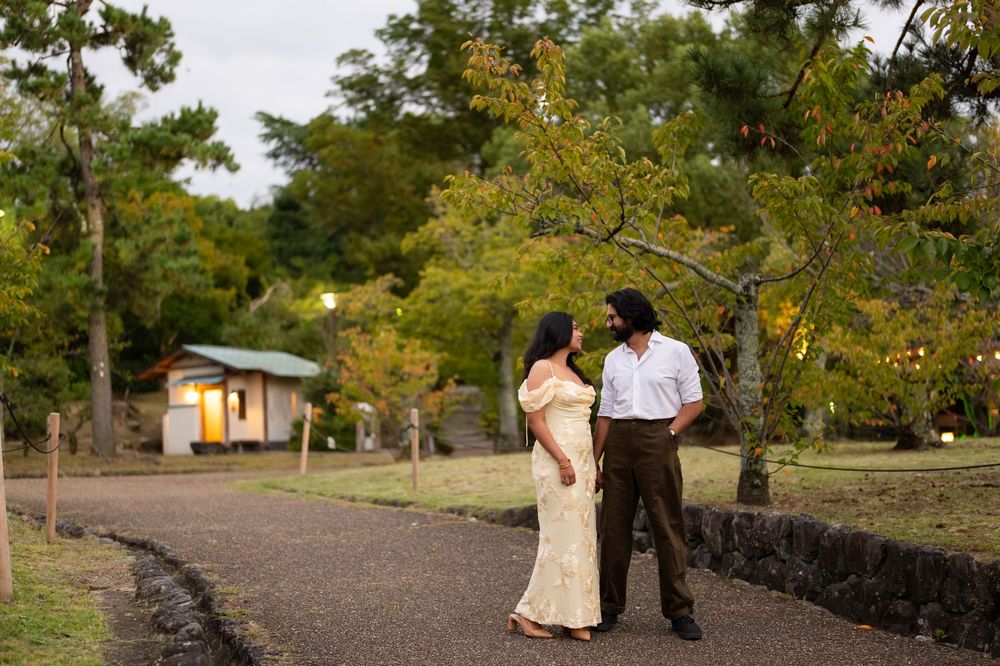 Couple sharing a tender moment on a scenic park pathway surrounded by autumn trees.