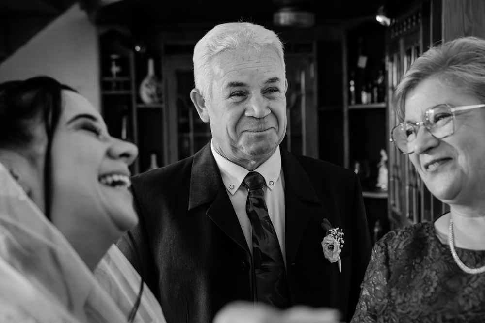Wedding guests in formal attire share candid moments at the reception.