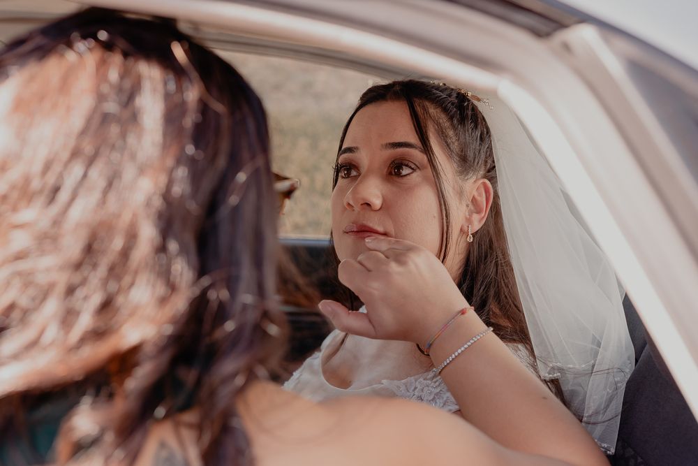 Wedding party members share a moment inside a vehicle.