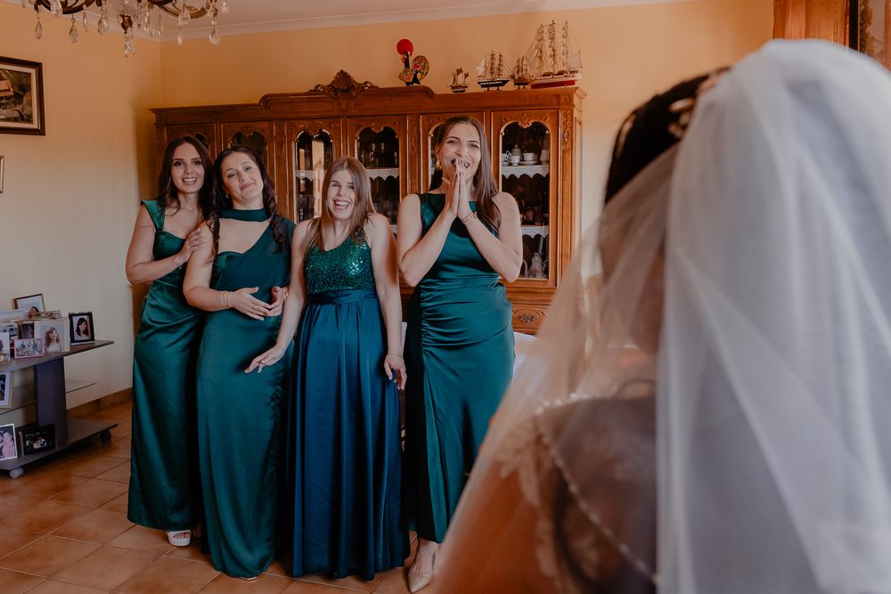 Bridesmaids in teal dresses gather during a wedding celebration.