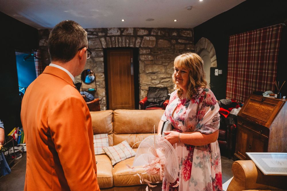 People gather in a rustic room with exposed stone walls during an event.
