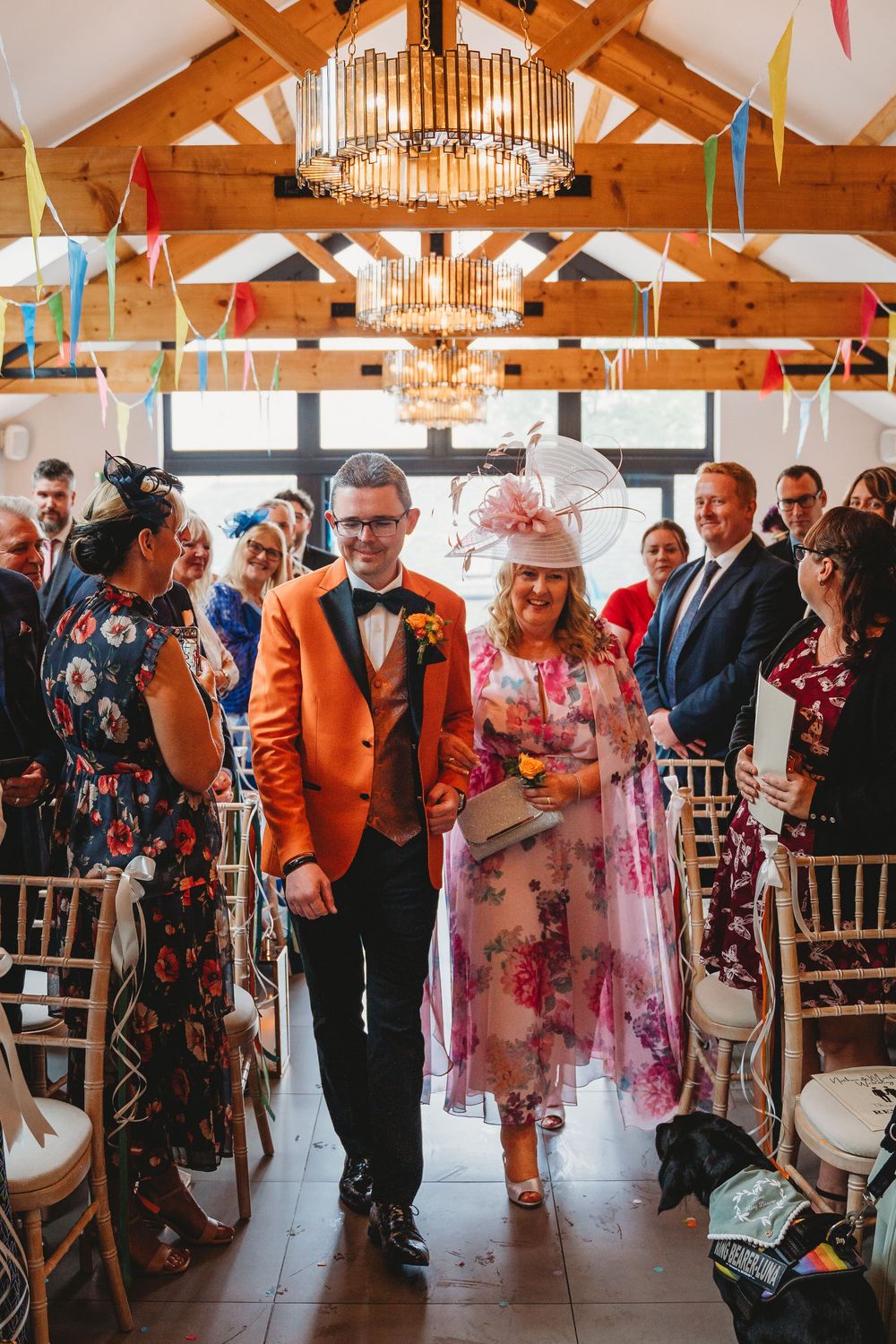 Groom entrance in his orange suit at his gay wedding Gellifawr Woodland Retreat
